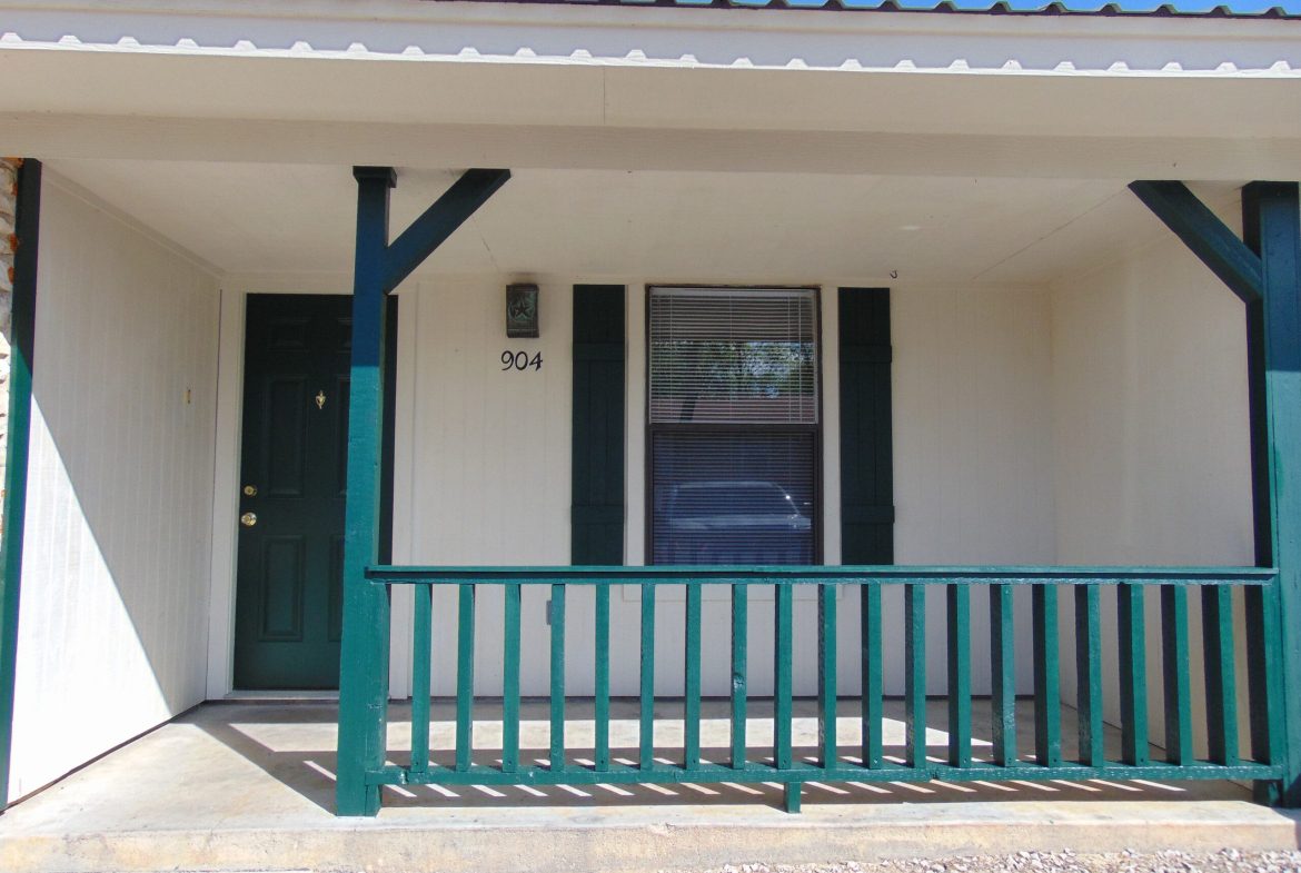 Here's an alt tag for the image: Building entrance, porch, green railing, 904.