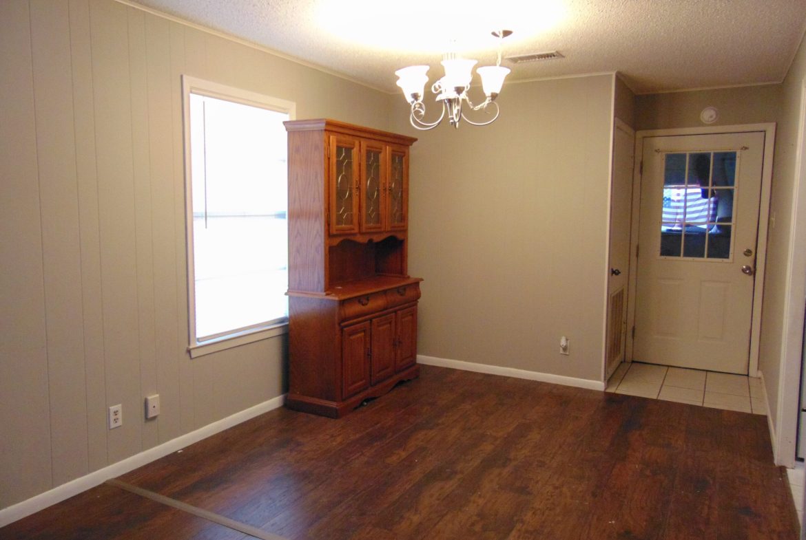 Empty dining room with wooden hutch.