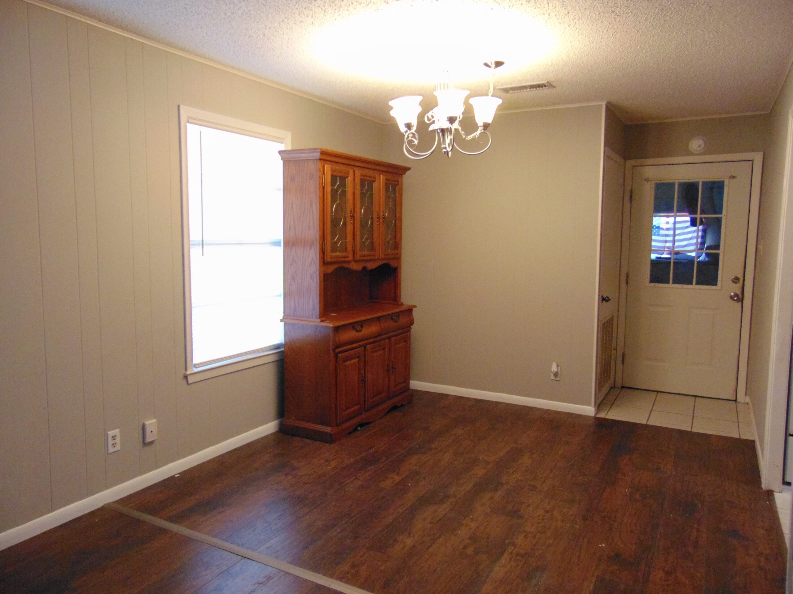 Empty dining room with wooden hutch.