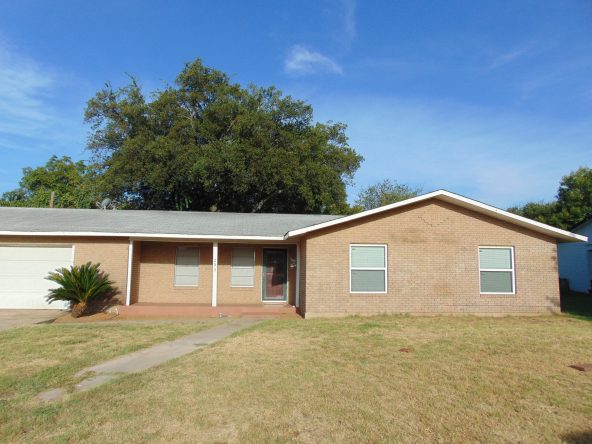 Brick ranch house with yard and tree.