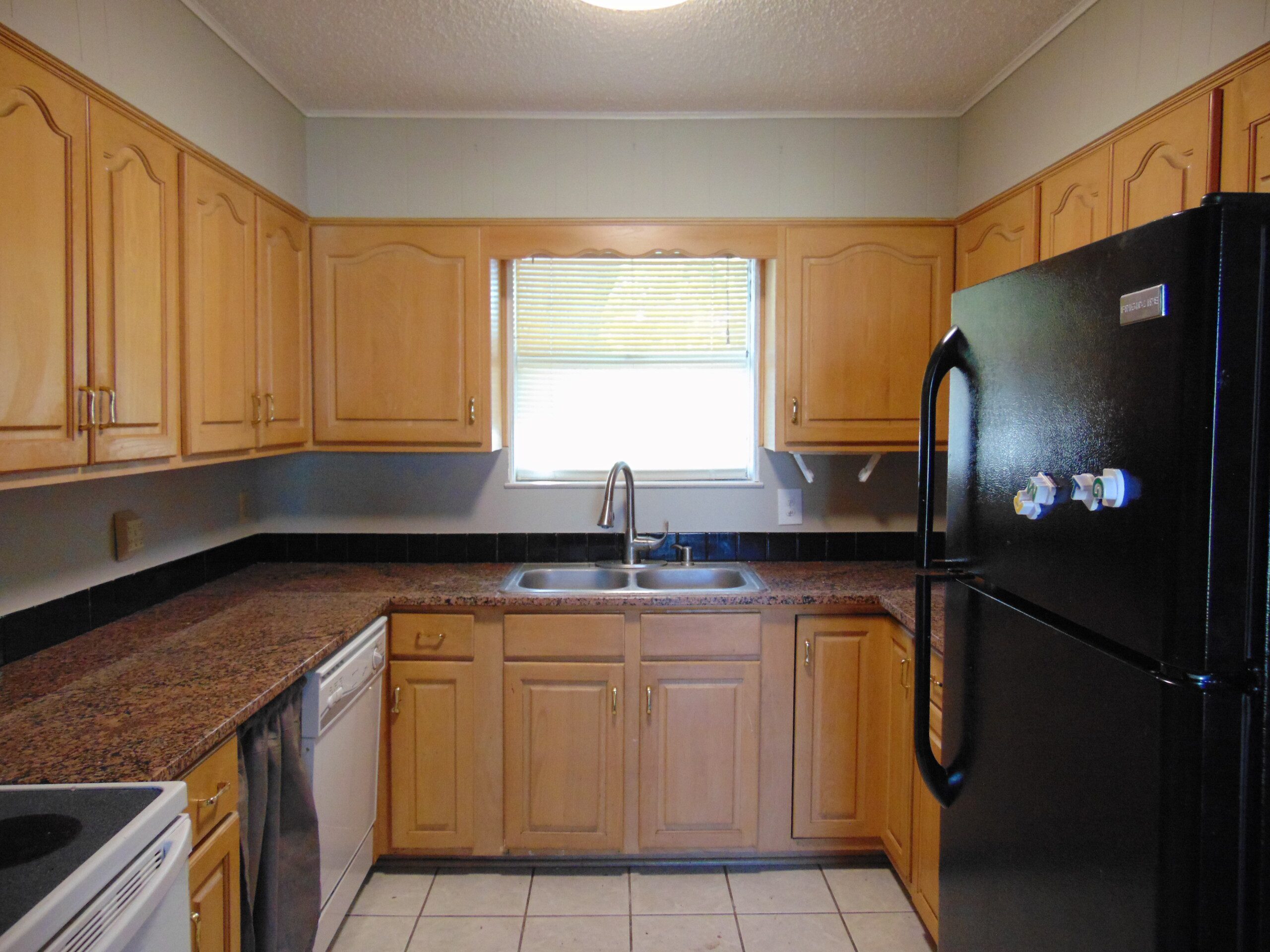 Kitchen with wood cabinets and granite counters.