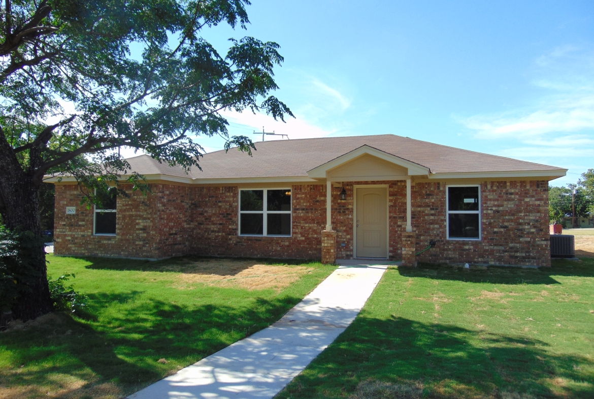 Brick house with walkway and green lawn.