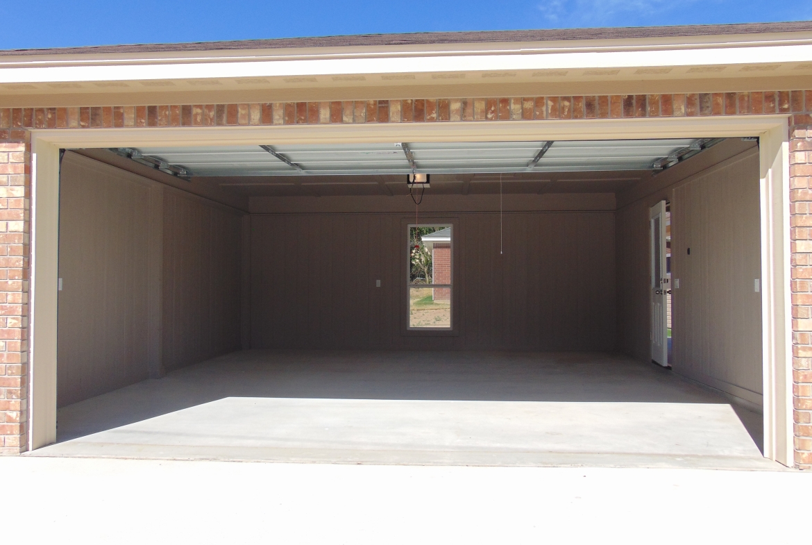 Empty new garage with open door.