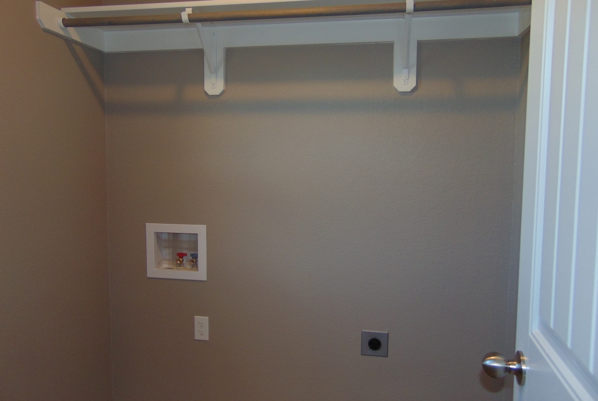 Empty laundry room with shelf and hookups.