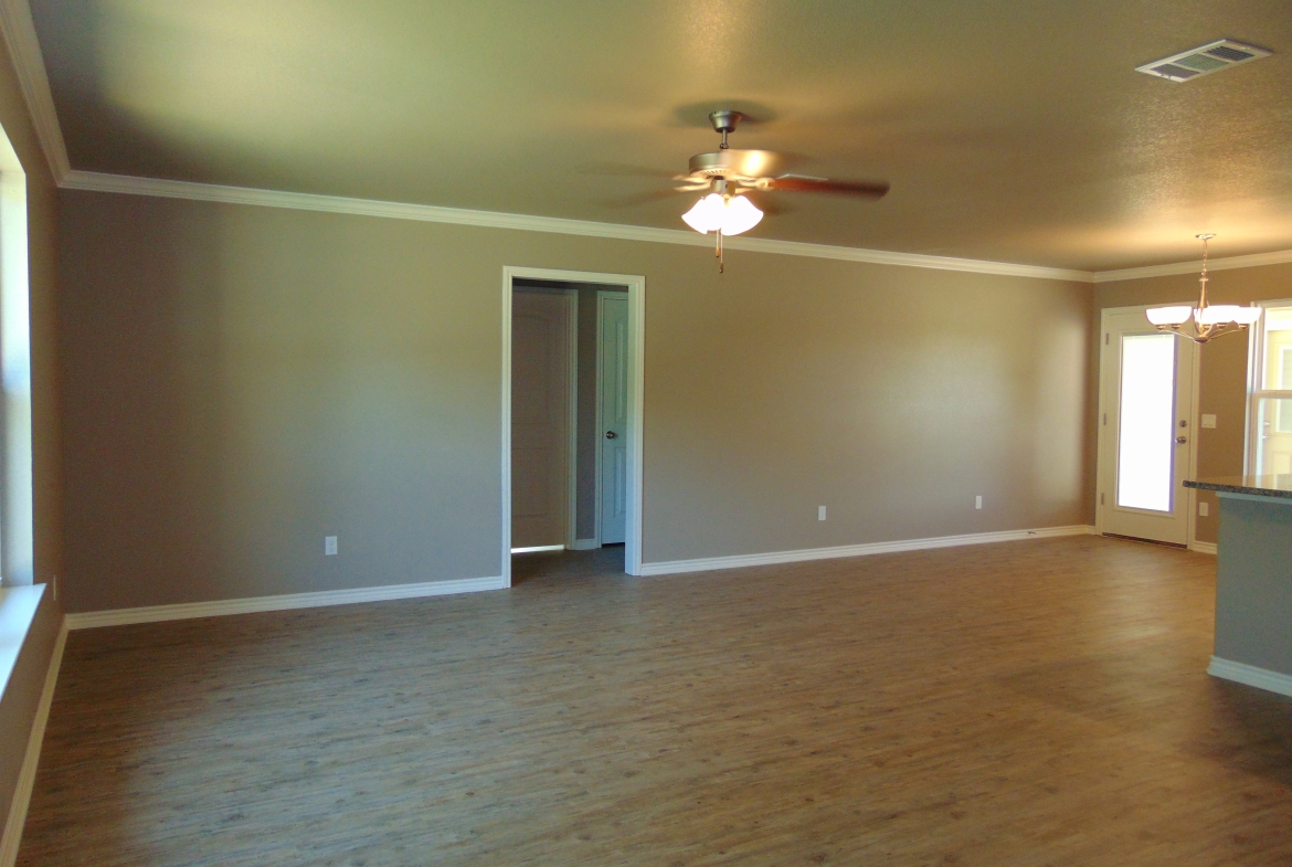 Empty room with wood floor and ceiling fan.