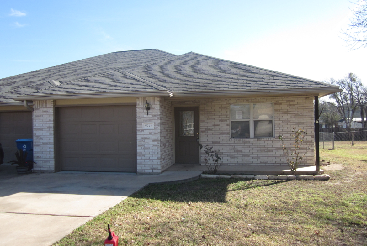 Brick duplex house with attached garage.