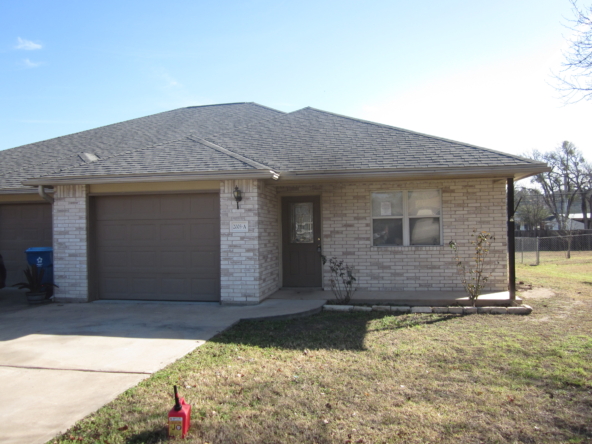 Brick duplex house with attached garage.