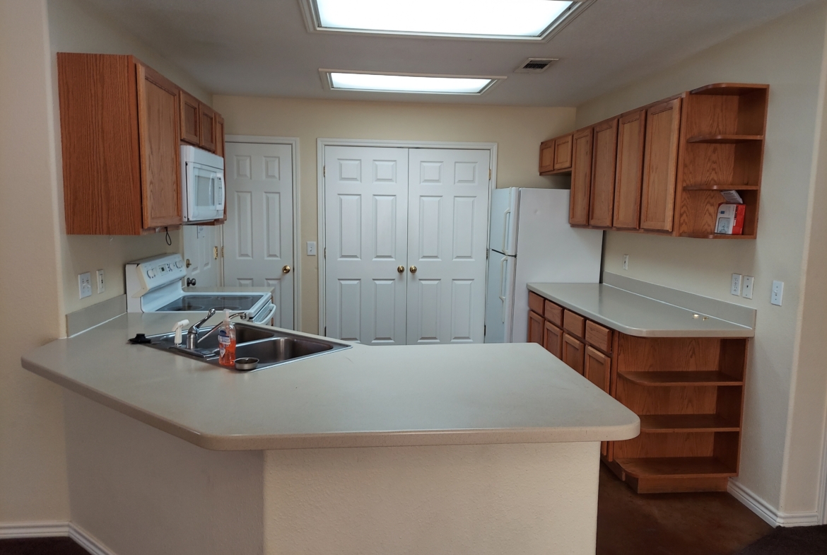 Empty kitchen with wood cabinets.