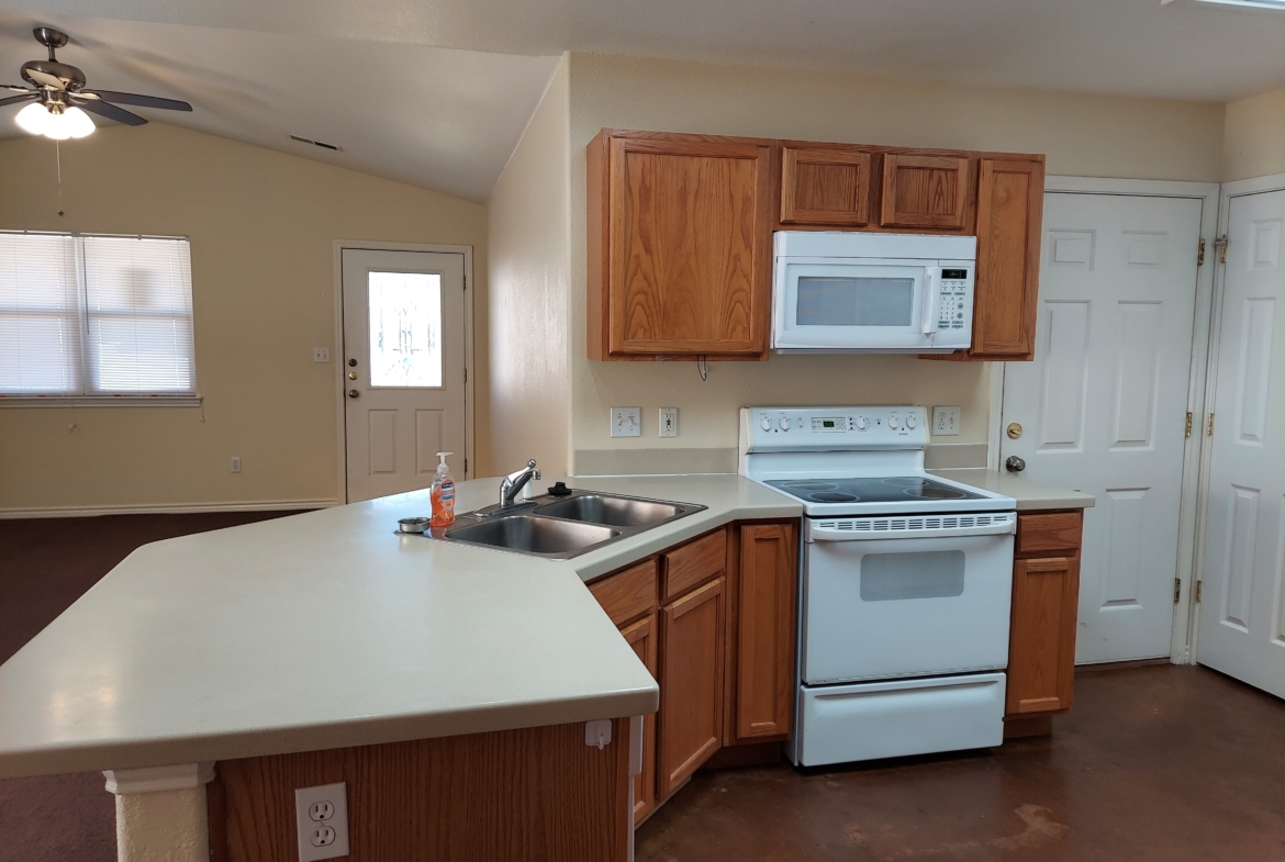 Kitchen with white appliances and wood cabinets.