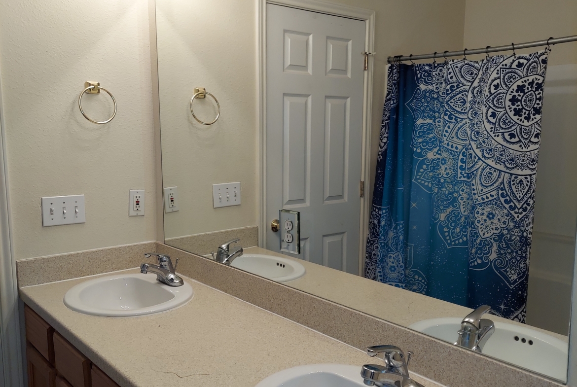 Bathroom vanity with double sinks and mirror.