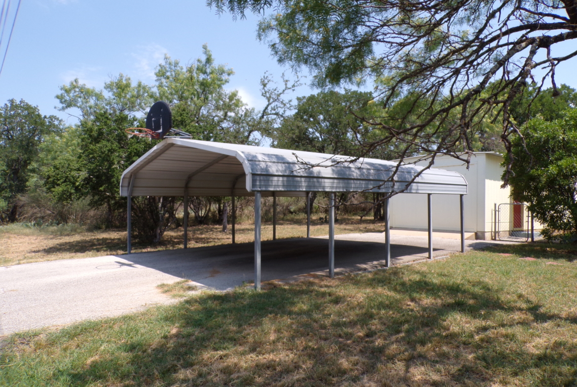 Metal carport with basketball hoop.