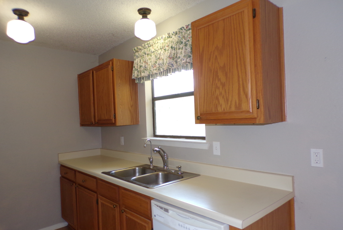 Kitchen with wood cabinets and sink.