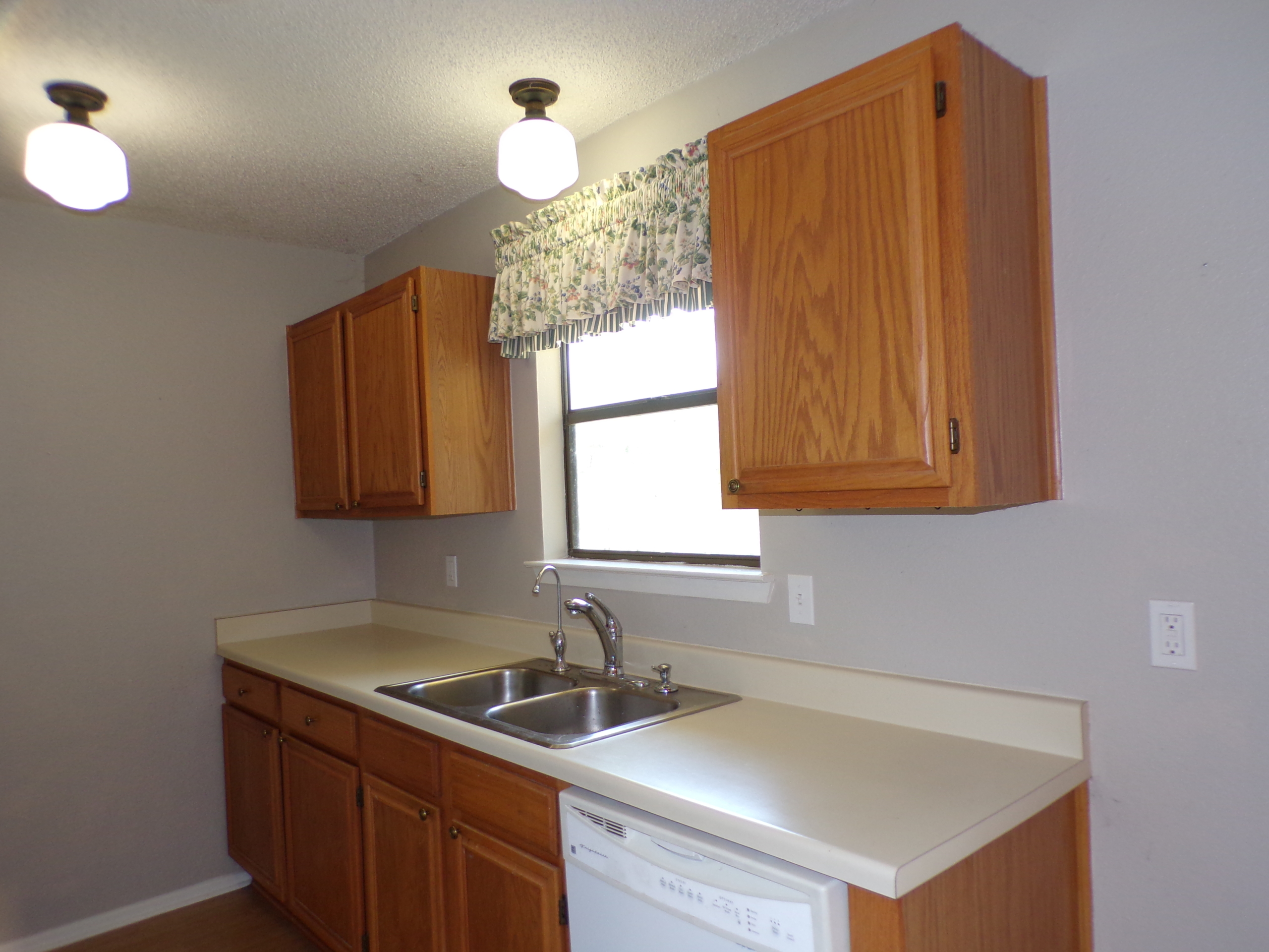 Kitchen with wood cabinets and sink.