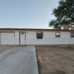 White brick house with garage and driveway.