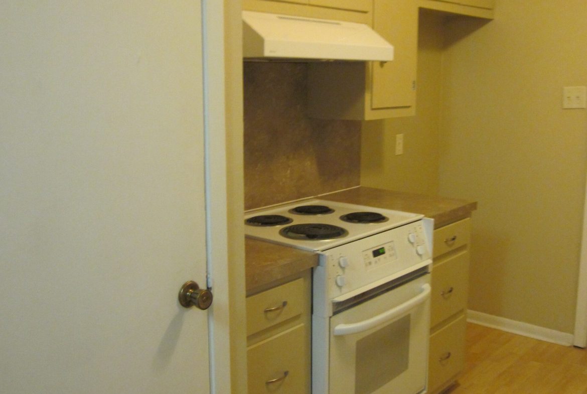 White kitchen stove and oven with cabinets.