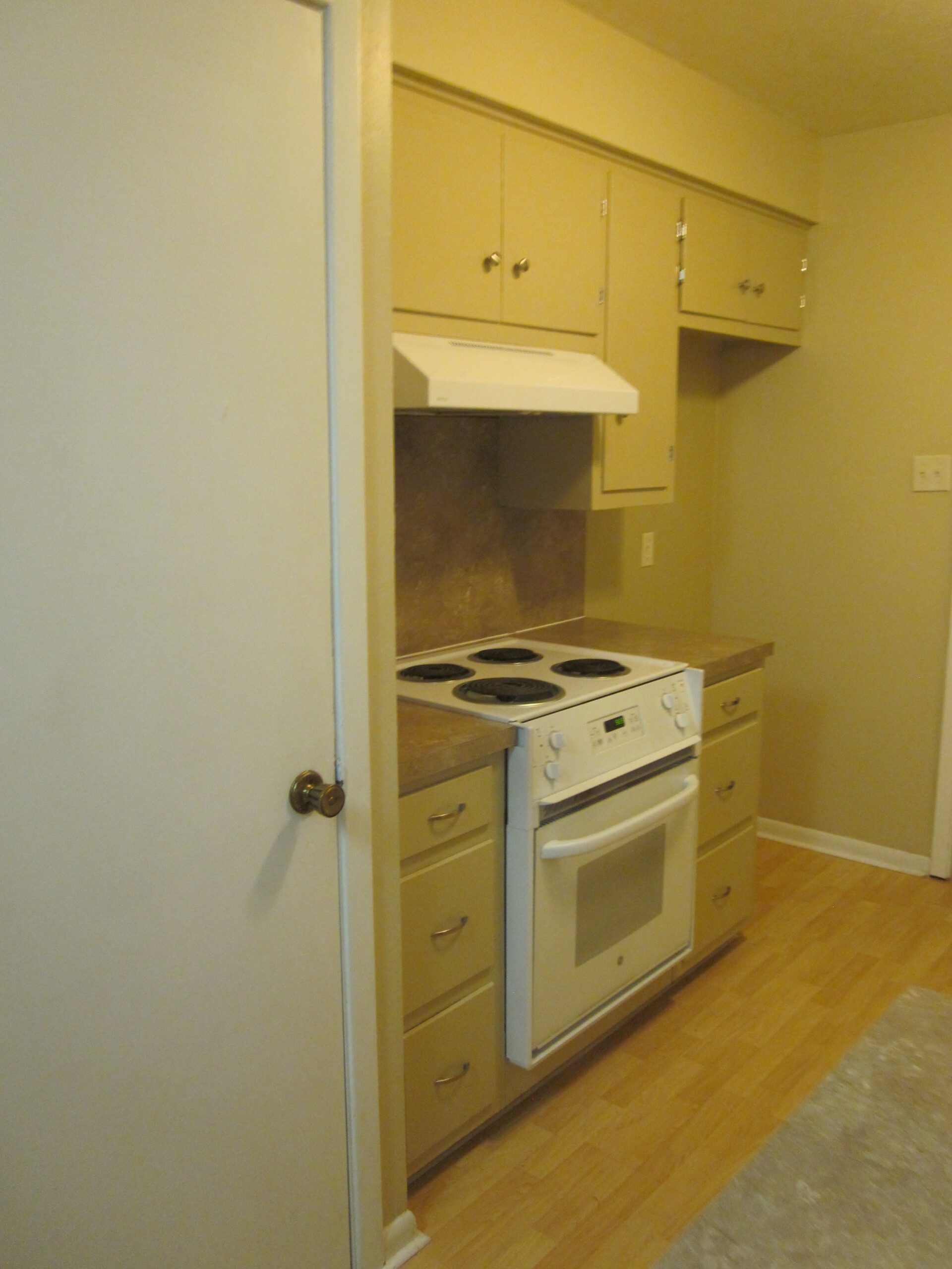 White kitchen stove and oven with cabinets.