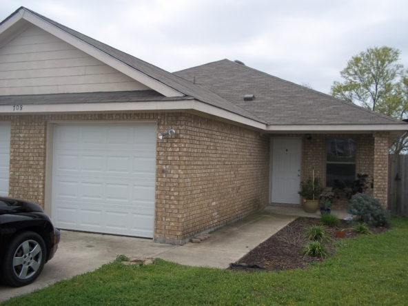 Tan brick house with attached garage.