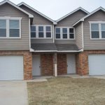 Here's an alt tag for the image: Dual-unit townhouse with garages.