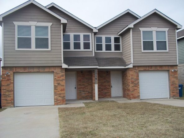 Here's an alt tag for the image: Dual-unit townhouse with garages.