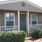 Gray house with green door and porch.