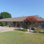 Brick apartment building with flowering tree.