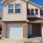Two-story house with garage and lawn.