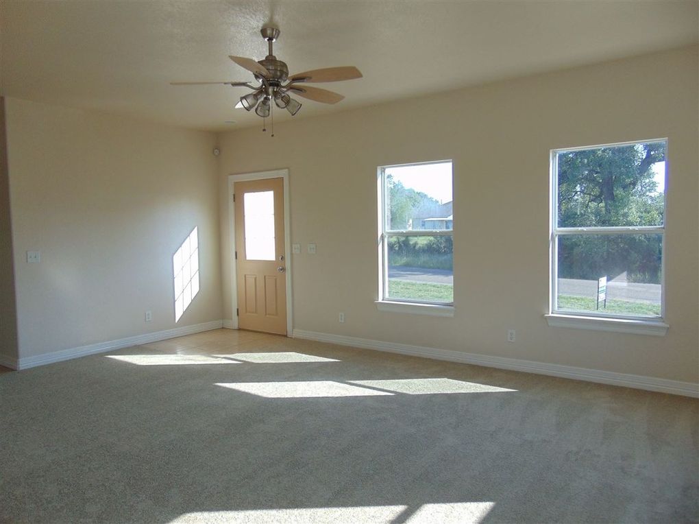 Sunny empty room with ceiling fan.