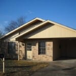 Brick ranch house with carport.
