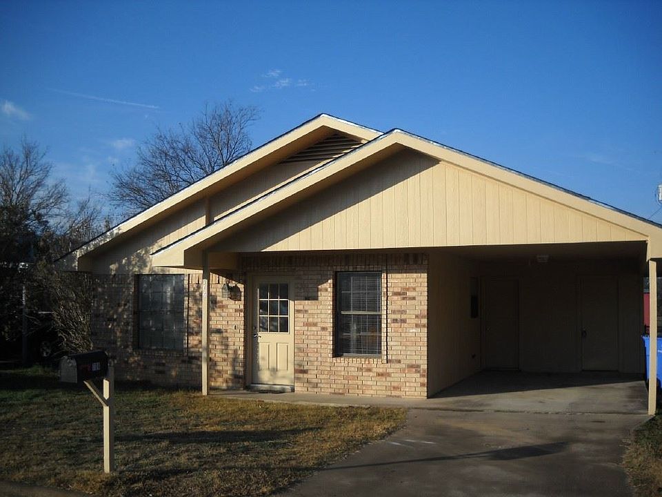 Brick ranch house with carport.