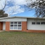 Here's an alt tag for the image: `Ranch-style house with brick facade`