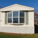 White mobile home with bay window.
