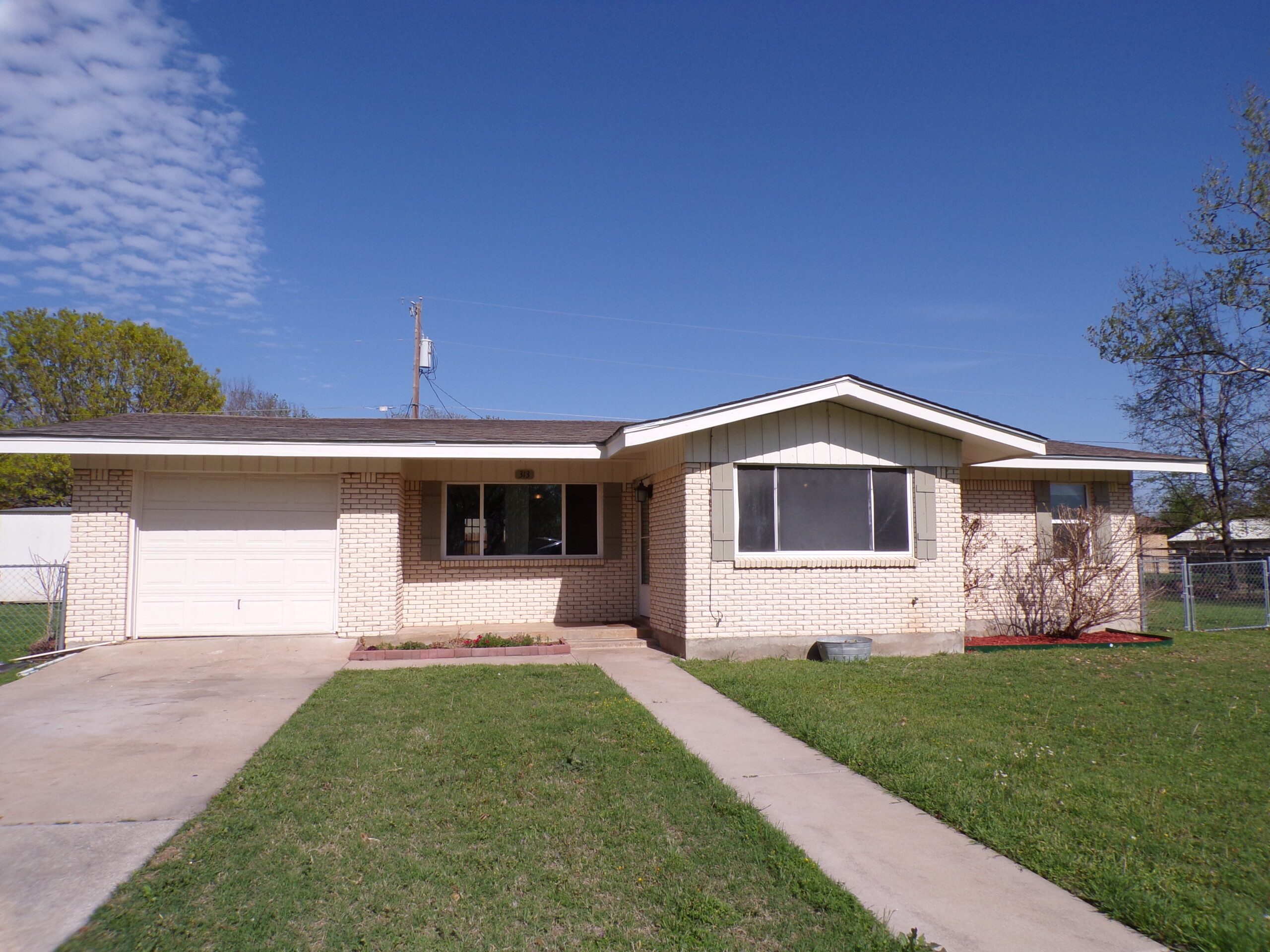 Ranch style house with yard and driveway.