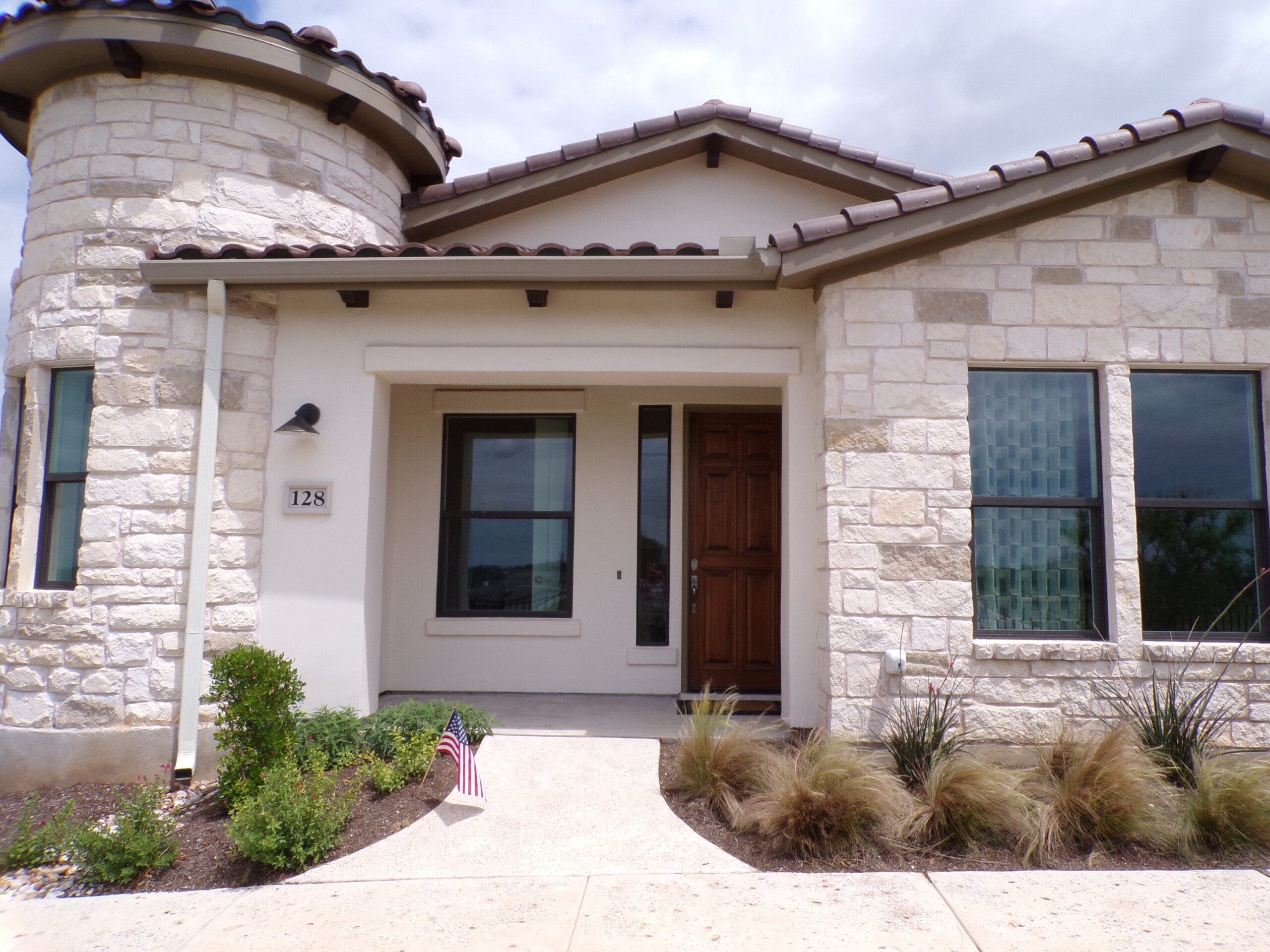 Stone house with brown door, American flag.