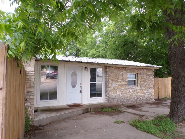 Stone house with white door and windows.