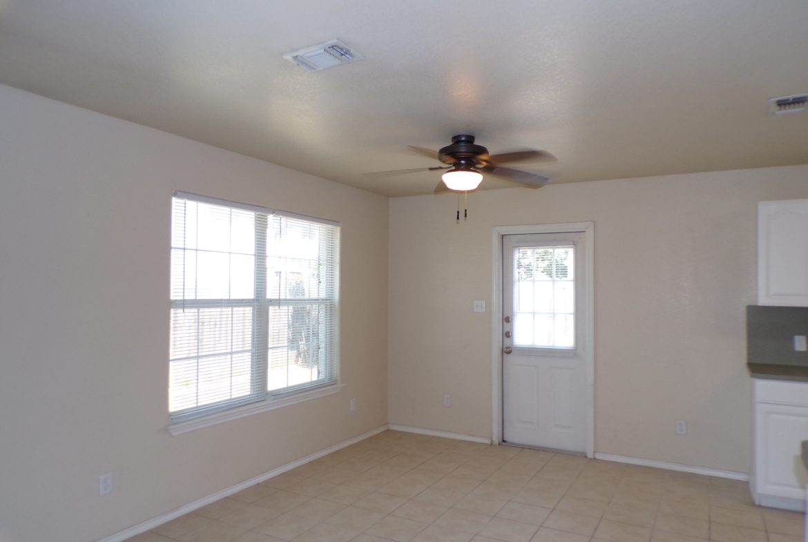 Empty room with tile floor, window, and door.