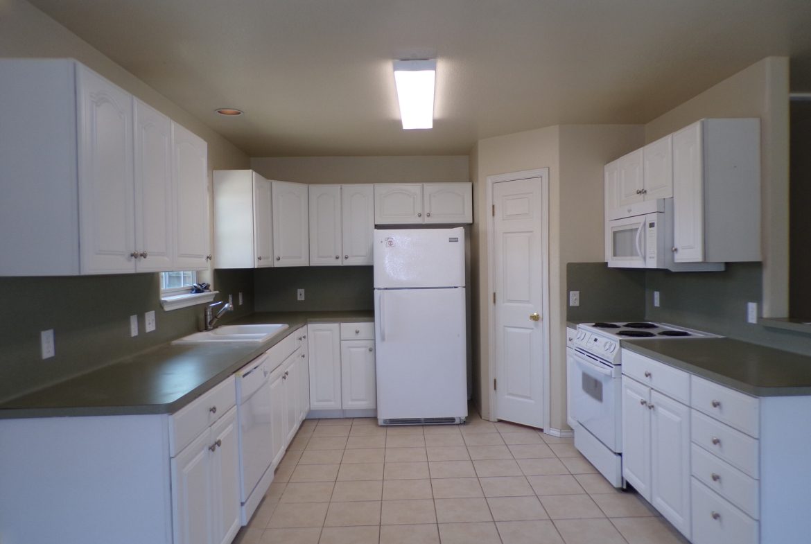 White kitchen with appliances and cabinets.