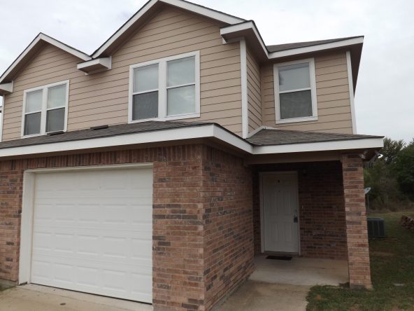 Two-story brick house with garage.