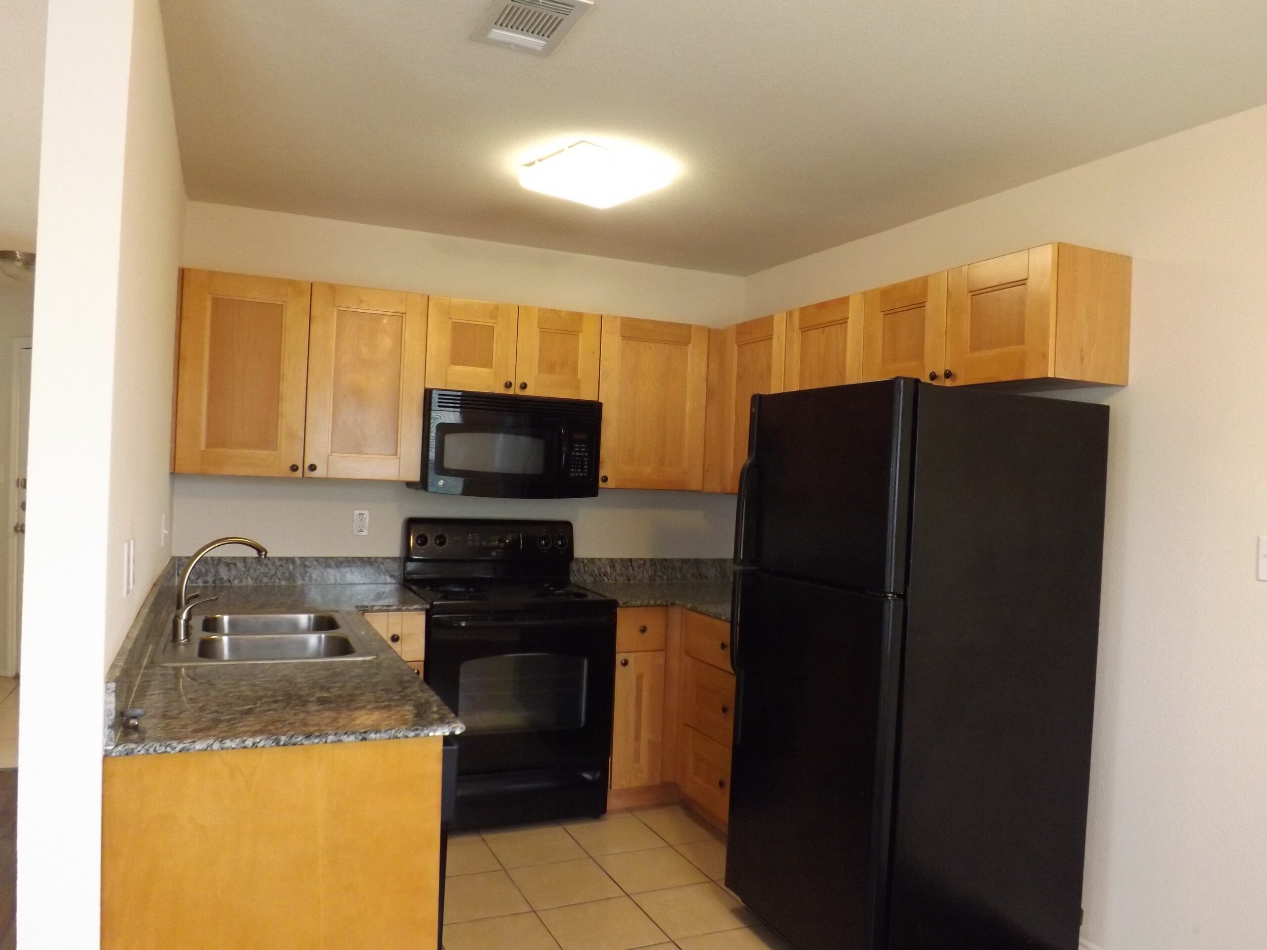 Apartment kitchen with black appliances.