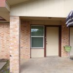 Brick house entrance with beige door.