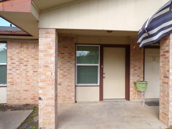 Brick house entrance with beige door.