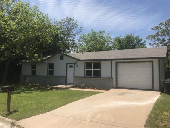White house with garage and lawn.