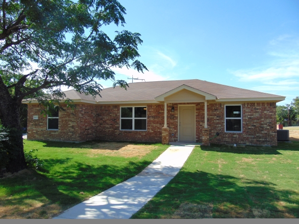 Brick house with walkway and green lawn.