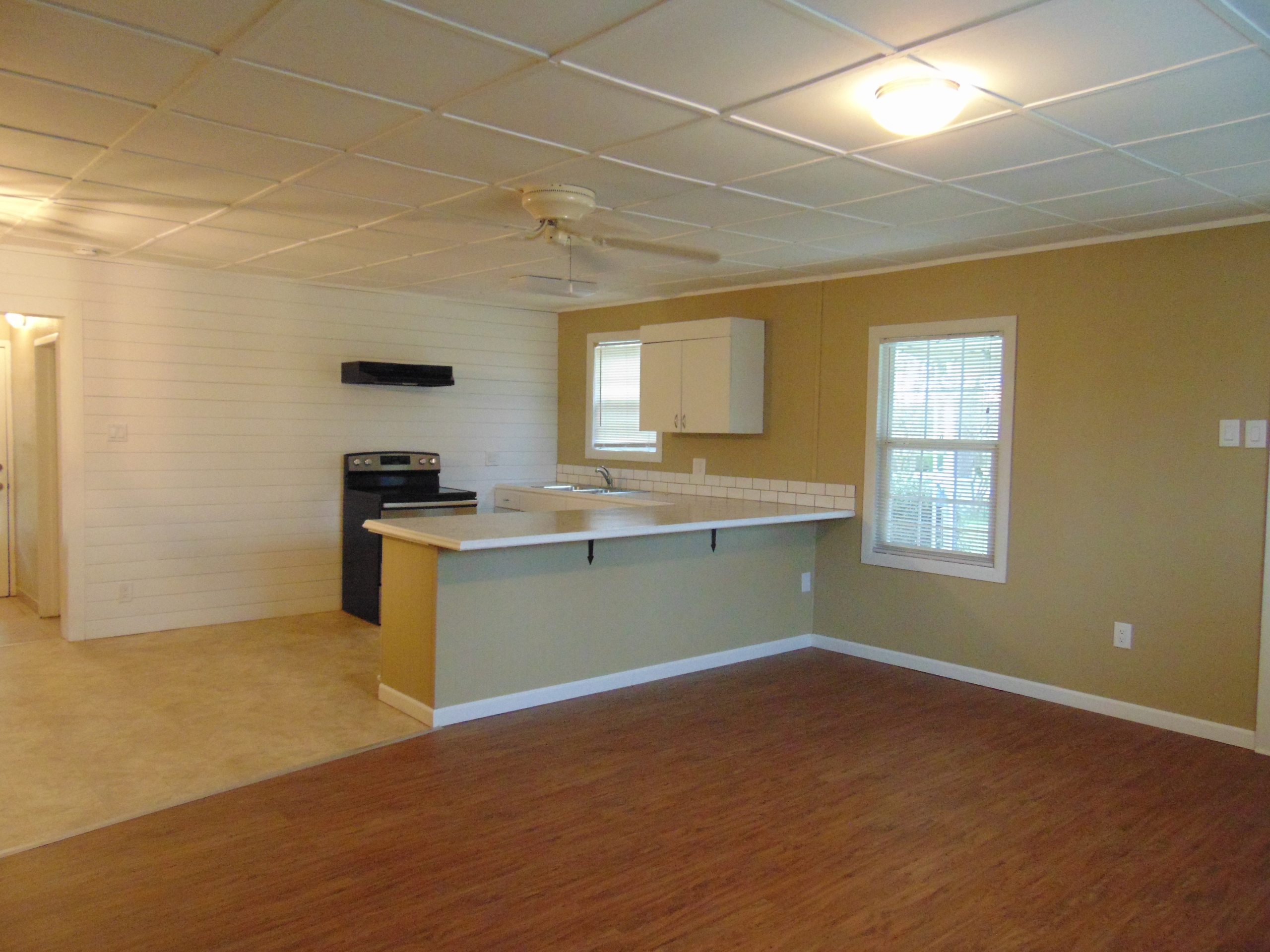 Kitchenette with wood floor and ceiling fan.
