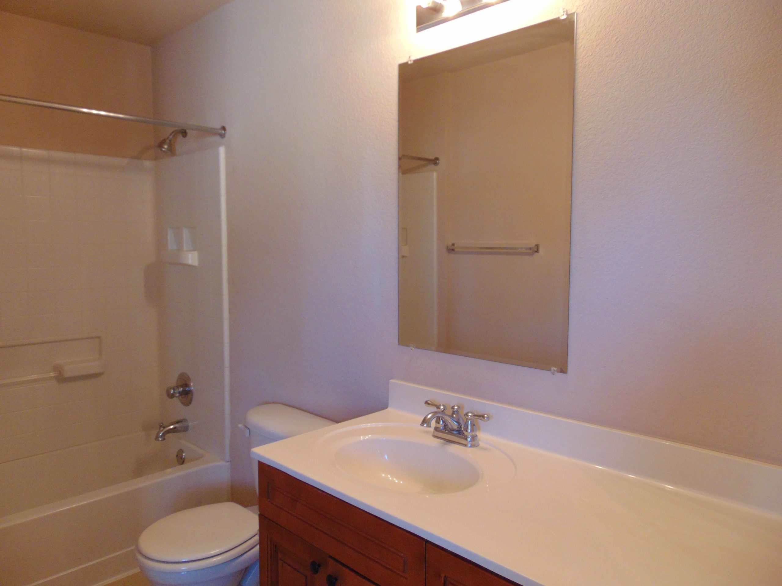 Clean bathroom with tub, toilet, and sink.