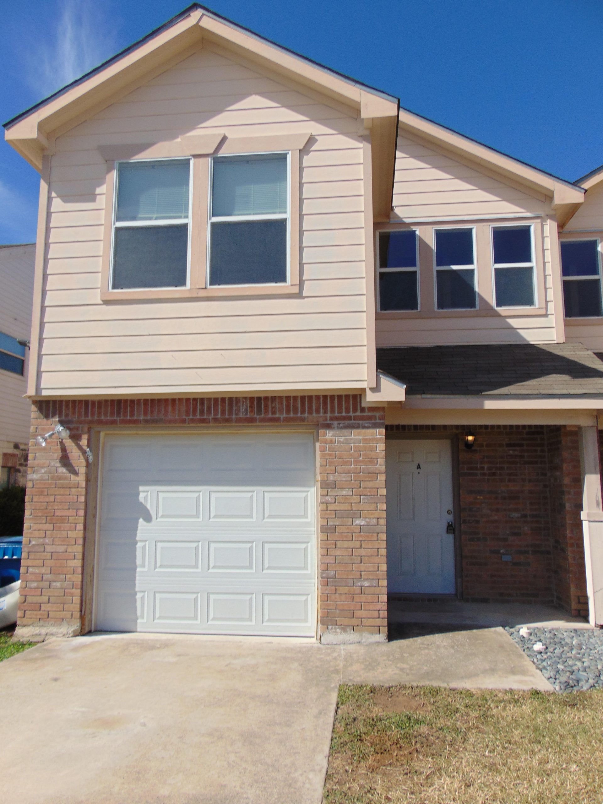Two-story house with garage and front door.