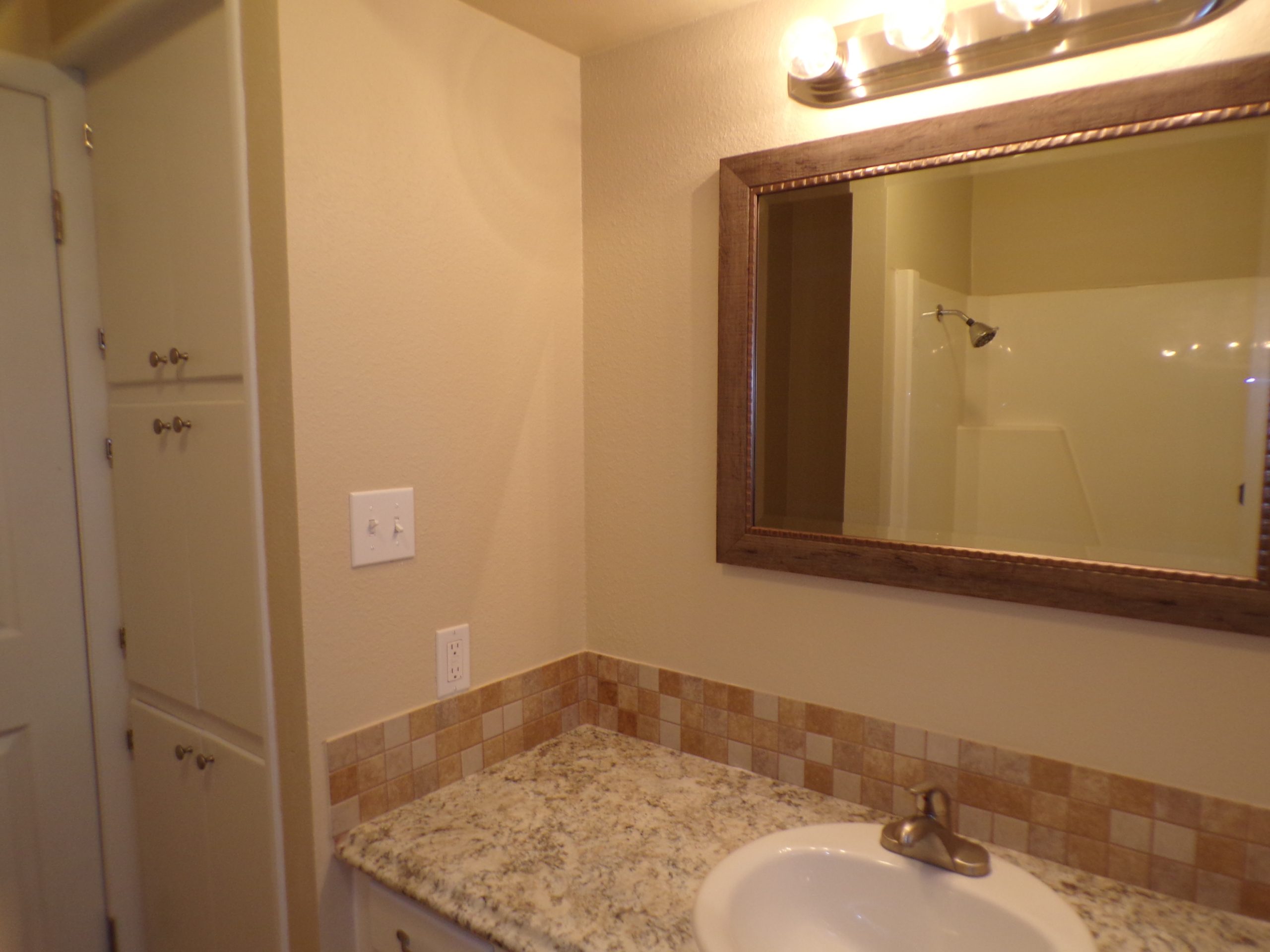 Bathroom vanity with sink and mirror.