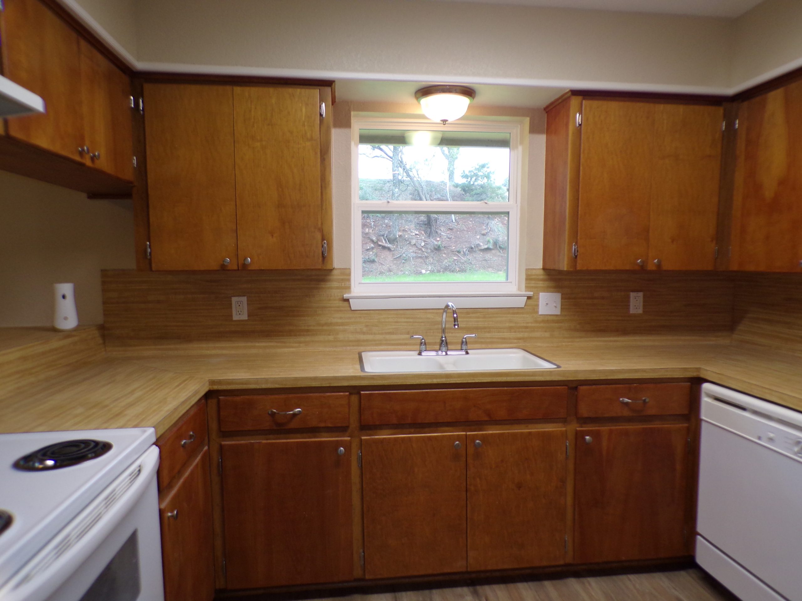 Kitchen with wood cabinets and window.