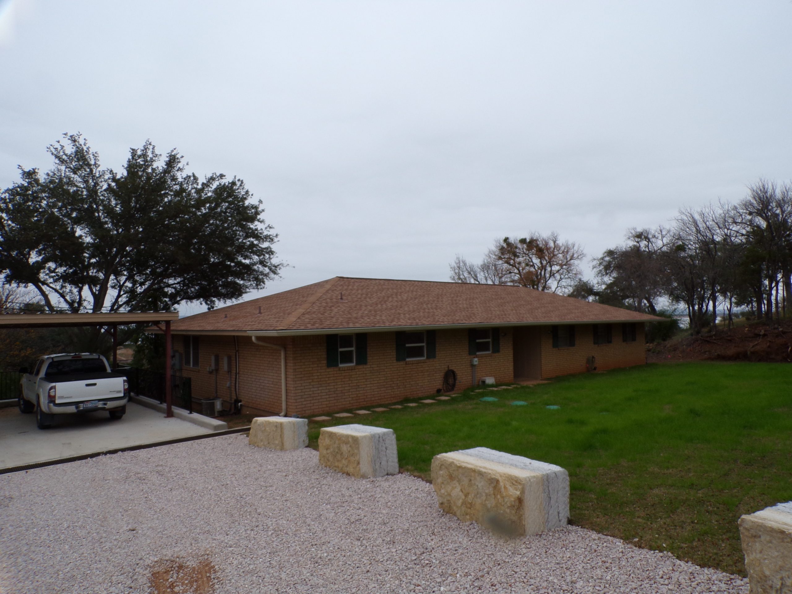 Brick ranch house with truck in driveway.