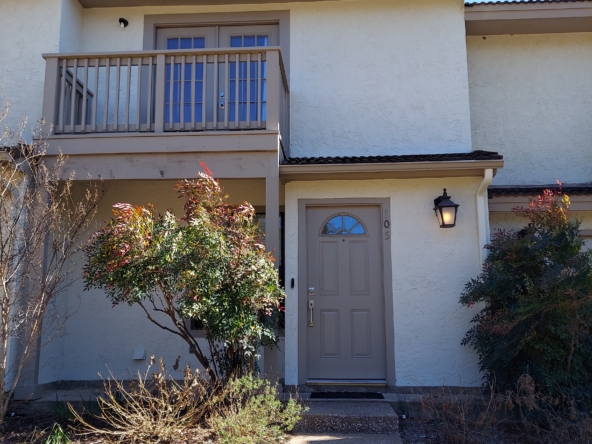 Tan stucco condo building, entrance.