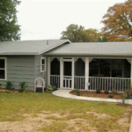 Gray house with screened porch and yard.